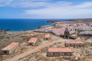 Abandoned buildings overlooking the coast of Tenerife with a scenic ocean backdrop.