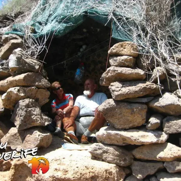 Inimesed istumas looduslikus kivivõlvis Tenerife saarel, Minu Tenerife teema.