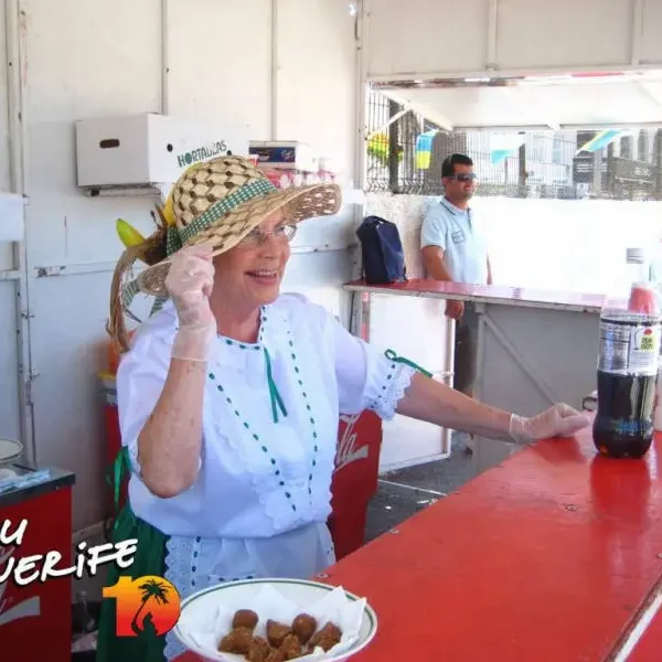 Terehüüdlik naine müügiletis Tenerife saarel, naeratades ja tervitades turiste.