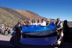 Kohaliku lipu ja grupipildiga Tenerife mägedes, rõhutades ilusaid vaateid ja kliimamuutusi.