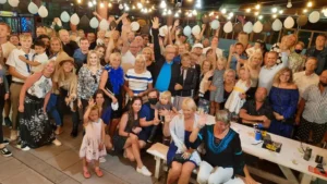 Pildil on suur grupp rõõmsaid inimesi Tenerife peol, rõõmsad ja sõbralikud.