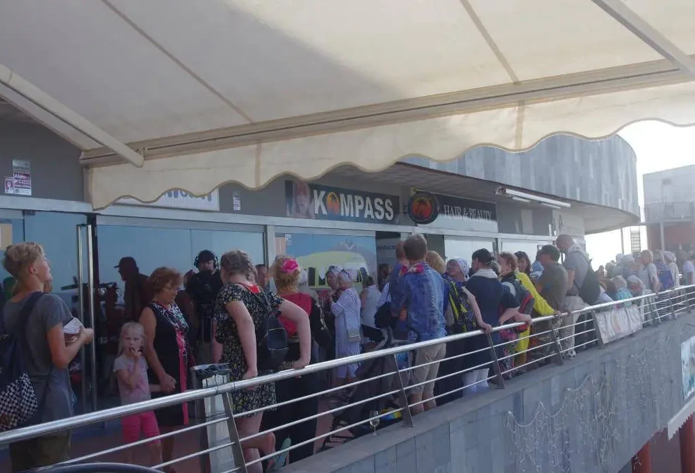 Järjekord Tenerife Kompassi turistiinfokeskuses, oodates infot ja teenuseid saare külastajatele.