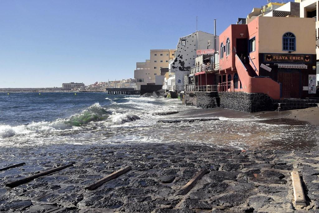 Tenerife rannaäär ja hooned, vaade ookeanile ja kaljuseintele, päikesepaisteline päev.
