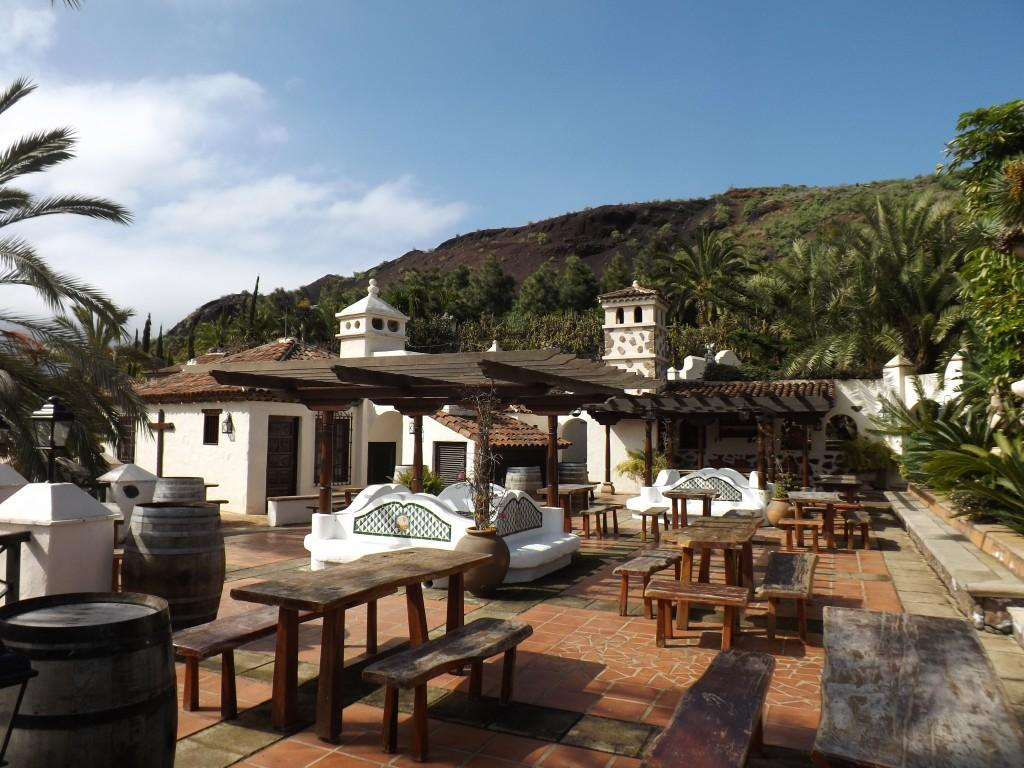 Kohaliku väikelinna väliõu Tenerife saarel, palmi- ja mägitaustaga.
